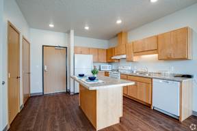 A kitchen with wooden cabinets and a white dishwasher.