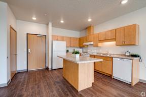 A kitchen with wooden cabinets and a white fridge.