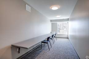 A conference room with a long table and chairs.