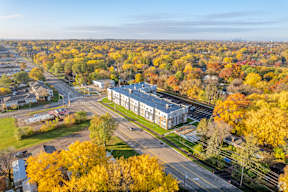 A large building is surrounded by trees with yellow leaves.