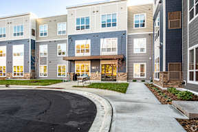 A modern apartment complex with a curved driveway in front.