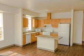 A kitchen with wooden cabinets and a white refrigerator.