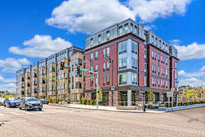AO Flats Building multi-story apartment building with cars parked in front.
