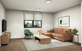 A living room with a green chair, a brown couch, and a wooden floor.