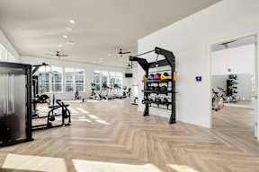 A gym with a variety of equipment including weights and a rowing machine.