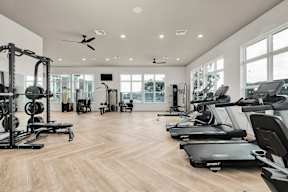 A spacious gym with treadmills, weights, and exercise equipment.