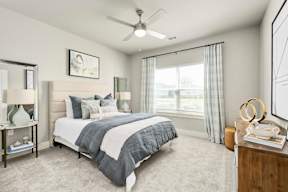 A bedroom with a large bed and a ceiling fan.