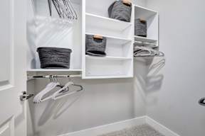 A white closet with hangers and shelves.