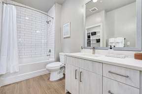 A white bathroom with a toilet, sink, and shower.