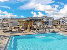 A swimming pool in a sunny outdoor setting.