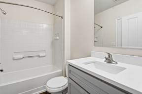 A white bathroom with a toilet, sink, and bathtub.