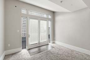 A room with a carpeted floor and a sliding door.