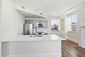 A kitchen with white cabinets and a white counter top.