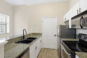 A kitchen with granite countertops and stainless steel appliances.
