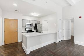 A kitchen area with a microwave, oven, and refrigerator.