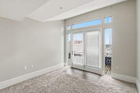 A room with a carpeted floor and a sliding glass door.