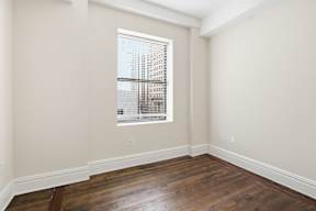 A room with a window and wooden floors.
