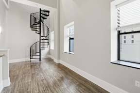 A spiral staircase in a room with light wood flooring.