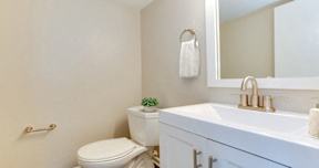 A white toilet sits next to a white sink in a bathroom.