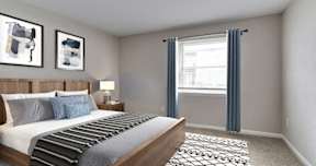 A bedroom with a bed, nightstand, and two pictures on the wall.