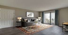 A living room with a grey couch, a rug, and a painting on the wall.