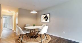 A dining room with a round table and chairs.