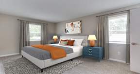 A bedroom with a large bed and a blue nightstand.