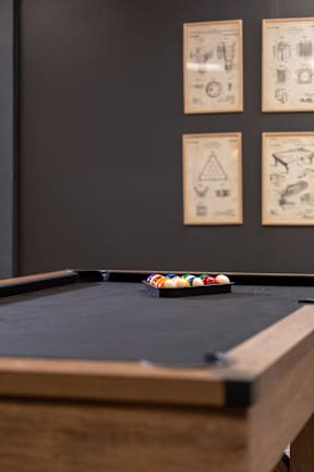 A pool table with a small pile of balls on it.