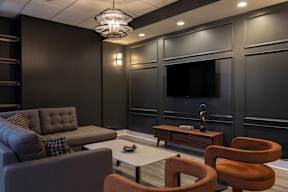 A modern living room with a grey sofa, a brown armchair, and a coffee table.