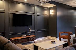 A modern living room with a flat screen TV mounted on the wall.