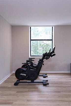 A stationary exercise bike is in a room with a window.