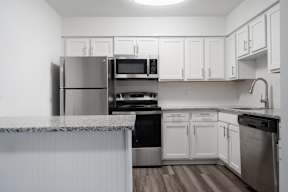 A kitchen with white cabinets and stainless steel appliances.