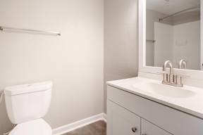 A white toilet sits next to a white sink in a bathroom.