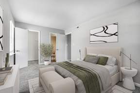 A bedroom with a large bed and a painting on the wall.