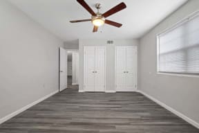 a living room with a ceiling fan and a door to a closet
