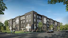 A modern apartment complex with a parking lot in front.
