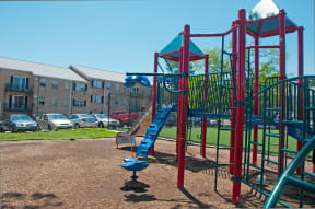 a playground with a slide in front of an apartment building