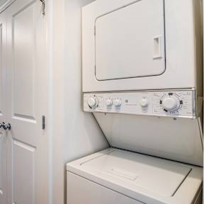 A white washing machine with a door and a control panel.