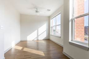 A room with wooden floors and a ceiling fan.