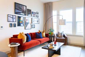 A living room with a red couch and a coffee table.