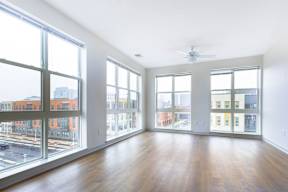 Empty room with wooden floor and large windows.