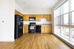 A kitchen with black appliances and wooden cabinets.