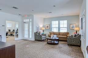 A living room with a brown carpet and furniture.