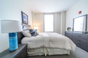 a bedroom with a bed and dresser and a window
