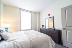 a bedroom with a bed and a dresser and a window