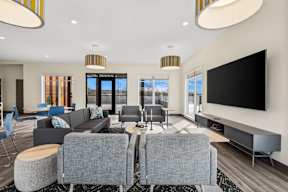 A modern living room with grey sofas and a large television.