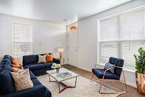 A living room with a blue sofa, a chair, and a coffee table.