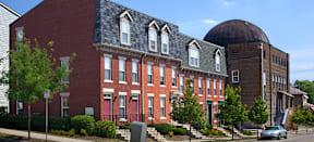 a red brick building with a large dome in the background