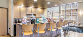 Bedford Hill clubhouse kitchen with a bar with chairs and bags on it