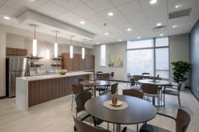 a dining room with tables and chairs and a kitchen